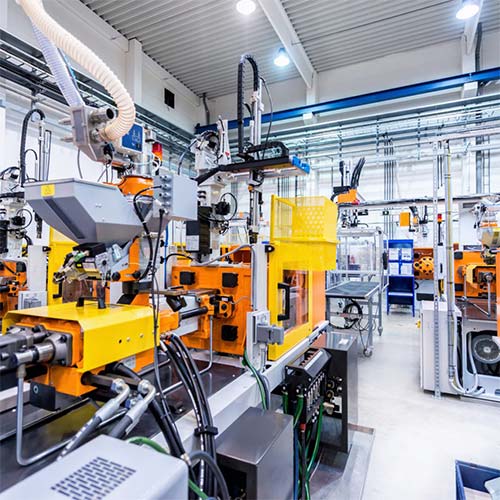 person using crane to move industrial gear box in engineering factory