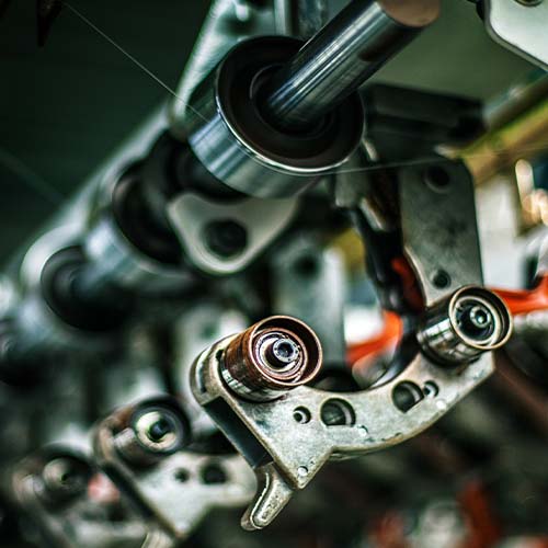 person using crane to move industrial gear box in engineering factory